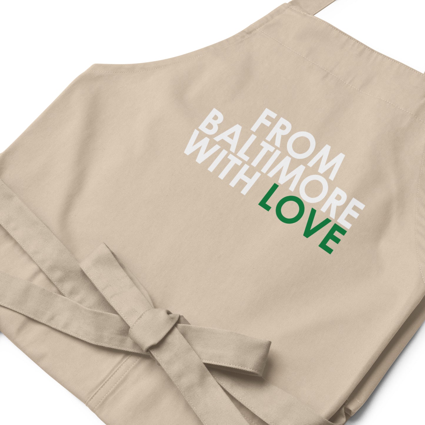 Green cotton apron by From Baltimore With Love™ with adjustable neck strap and front pockets, ideal for cooking or baking.