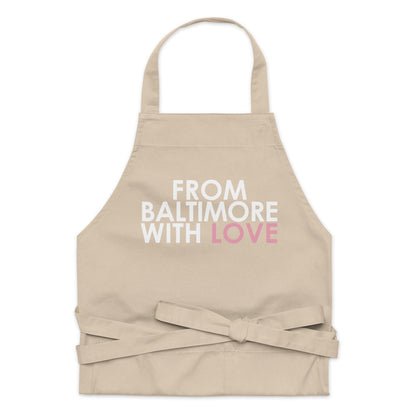 Pink cotton apron by From Baltimore With Love™ with adjustable neck strap and front pocket, perfect for cooking or baking.