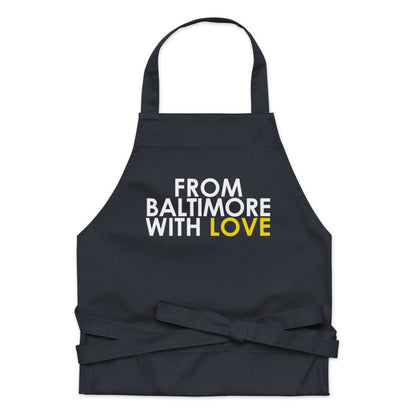 Yellow cotton apron from From Baltimore With Love™ featuring black text and adjustable neck strap, ideal for cooking or crafting.