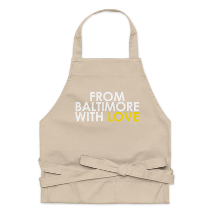 Yellow cotton apron from From Baltimore With Love™ featuring black straps and a practical design for cooking or baking.