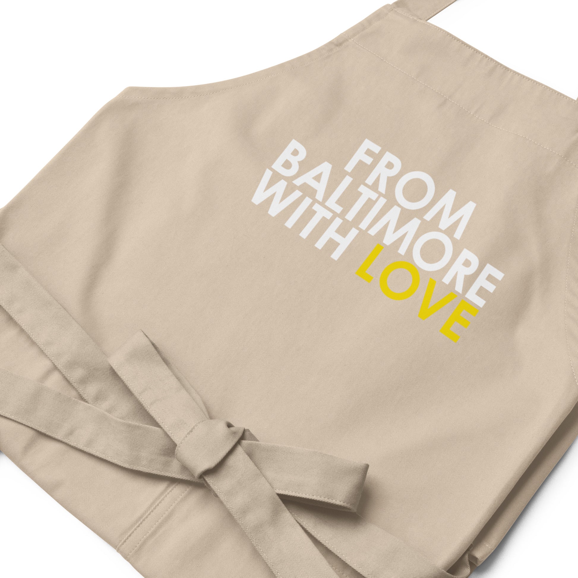 Yellow cotton apron by From Baltimore With Love™ with black straps, shown on a neutral background.