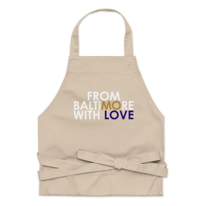 Black FBWL MO Love organic cotton apron by From Baltimore With Love™ shown on a person in a kitchen setting.